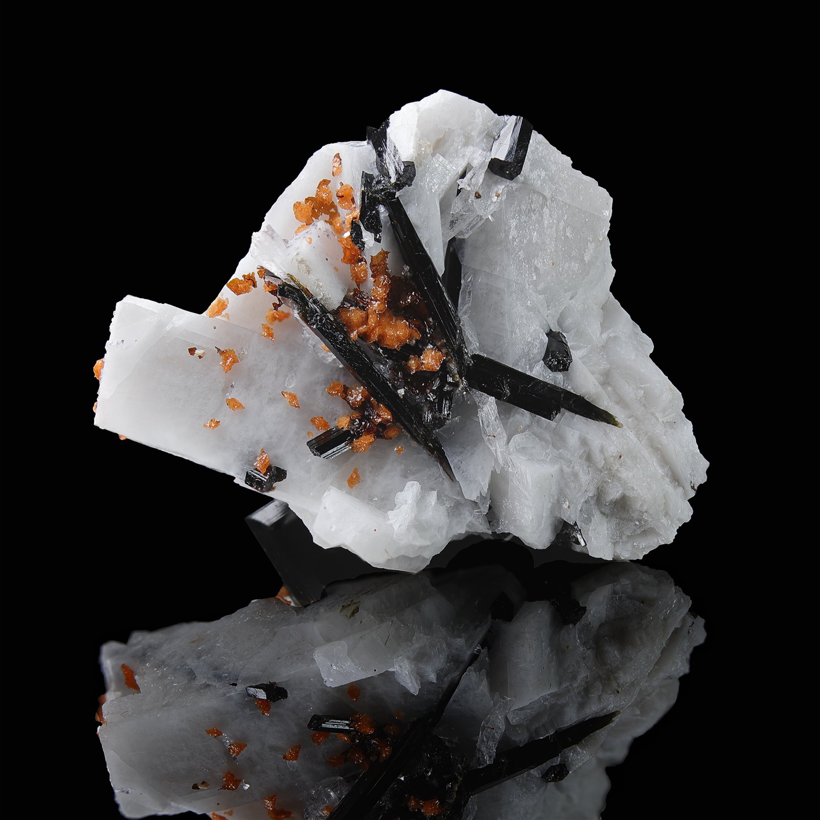 Black Aegirine Crystals and Orange Rhodochrosite Clusters On White Quartz from the Poudrette Quarry in Mont St Hilaire, Quebec, Canada.